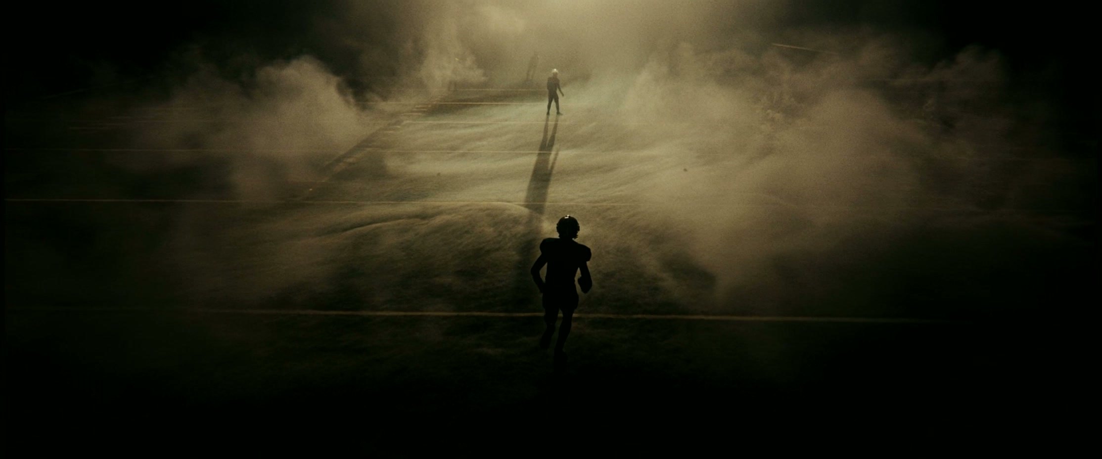 A lone figure running through dust and light